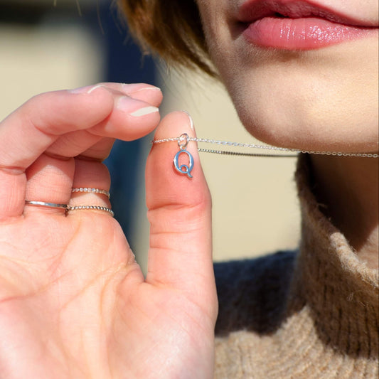 A model wearing the sterling silver initial necklace, showcasing its delicate and minimalist design.