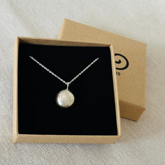 A sterling silver pebble pendant in an Impressums Jewellery branded gift box, ready for gifting.