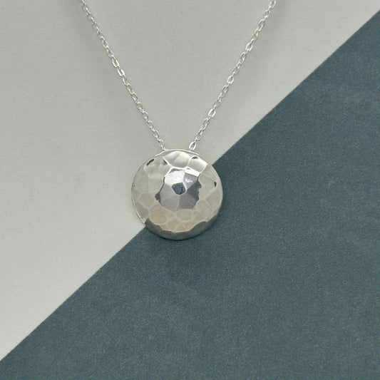 Handmade sterling silver mirror ball pendant with a hammered texture, displayed on an 18-inch silver trace chain.