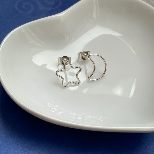 Handmade sterling silver mismatched moon and star stud earrings, 10mm x 10mm, displayed on a white background with butterfly scroll backs