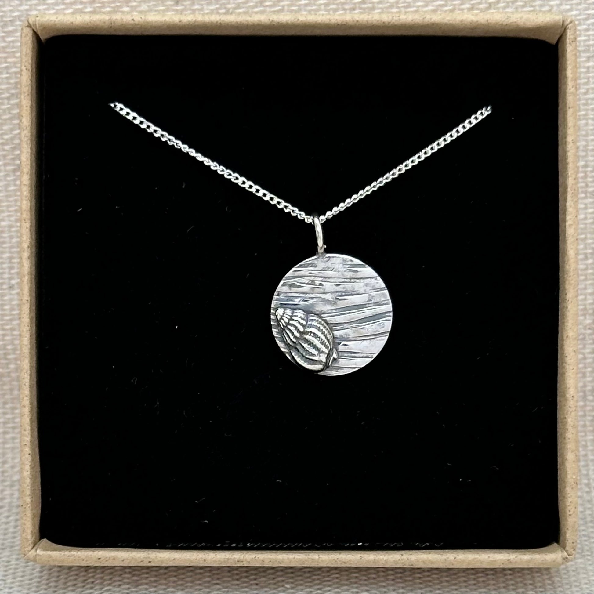 A sterling silver shell pendant in an Impressums Jewellery branded gift box, ready for gifting.