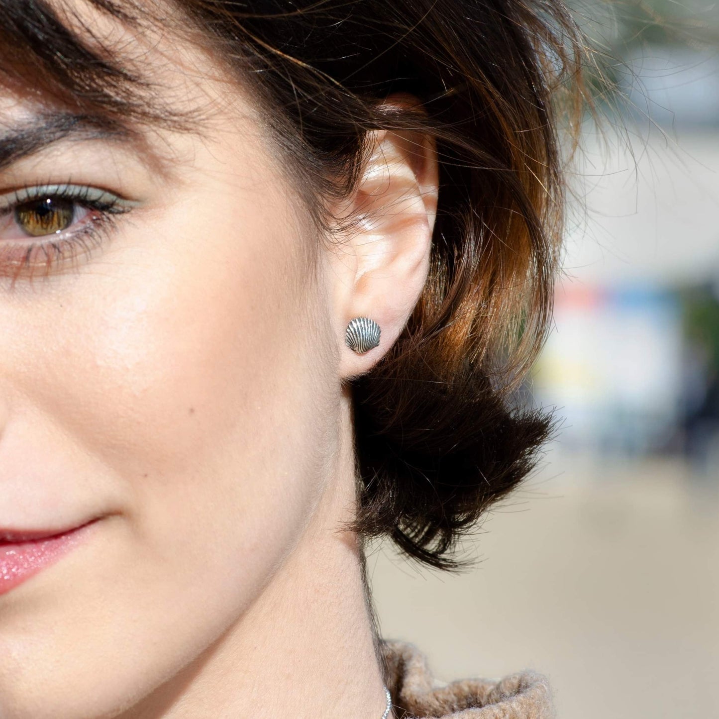 A model wearing the sterling silver cockle shell earrings, showcasing their natural and coastal-inspired design.