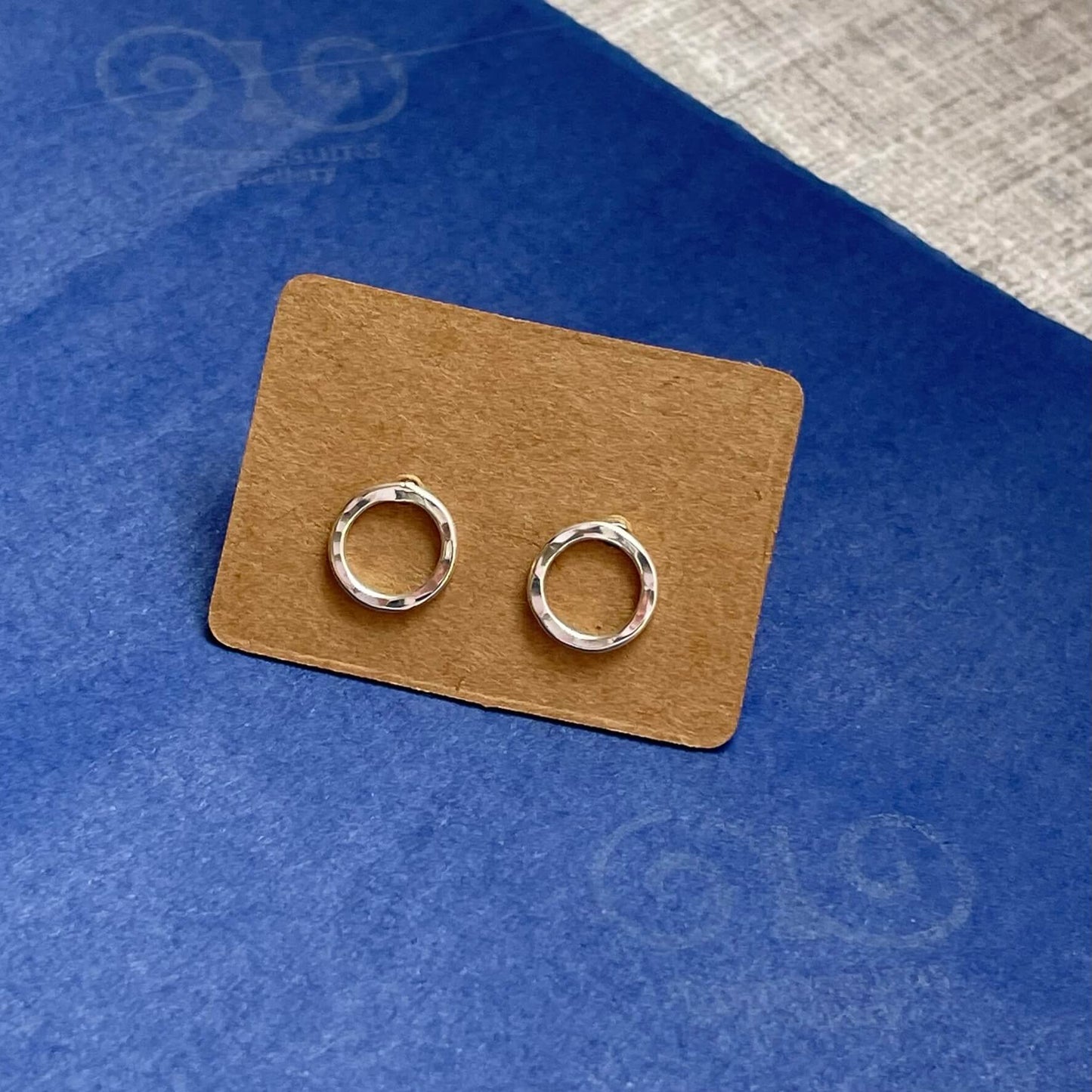 A pair of Sterling Silver Hammered Texture Circle Earrings pictured without a gift box,