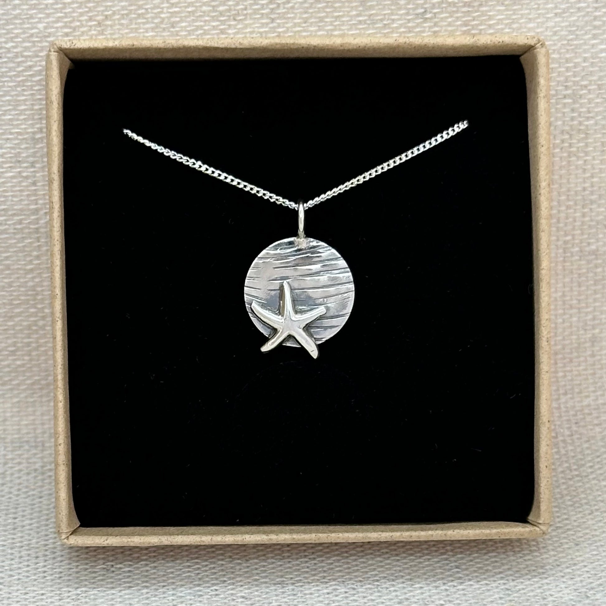 A sterling silver starfish pendant in an Impressums Jewellery branded gift box, ready for gifting