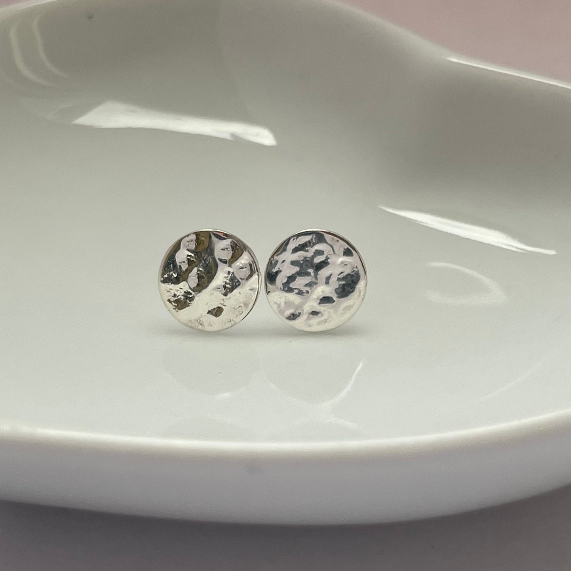 Handmade sterling silver hammered stud earrings with a textured finish, displayed against a white background
