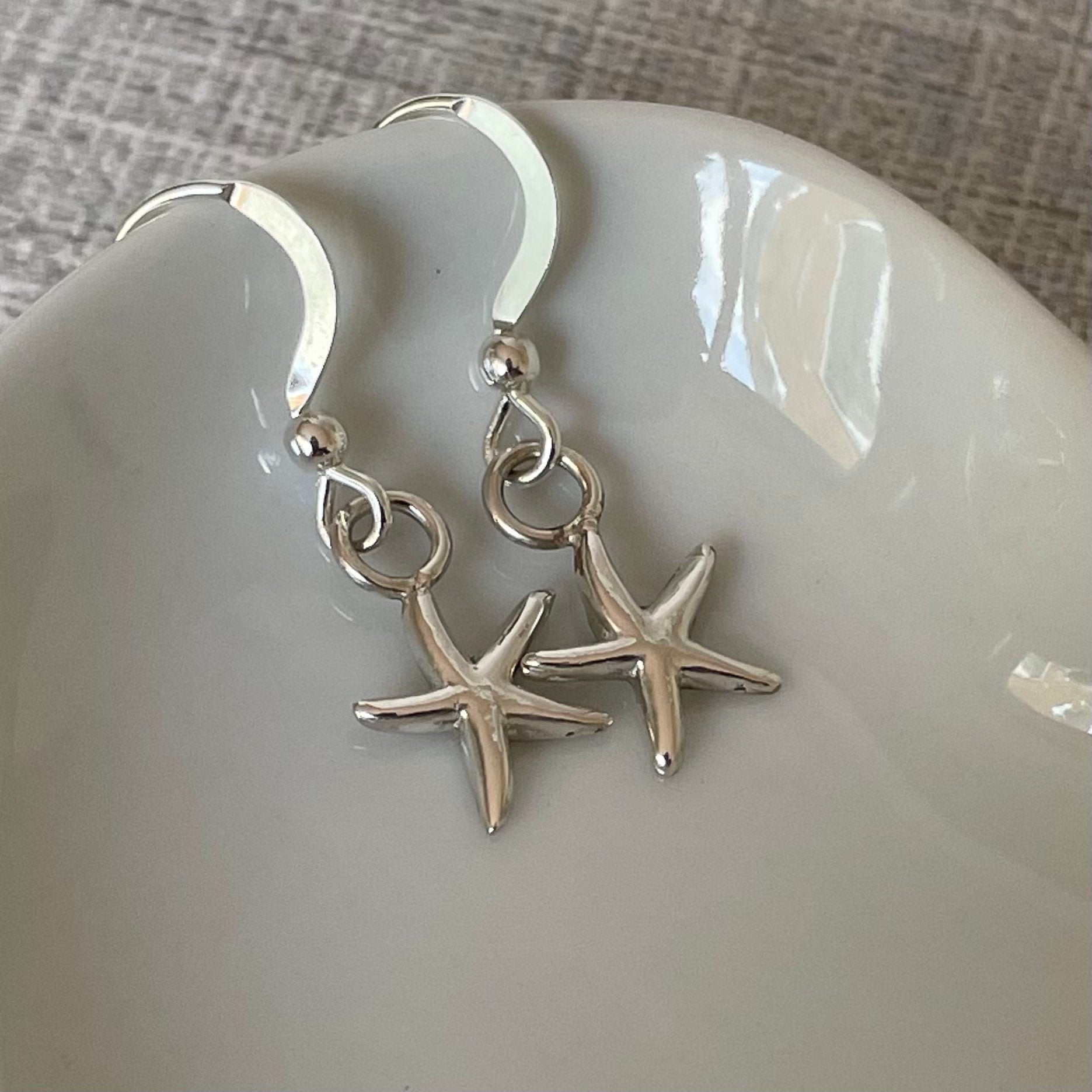 Handmade sterling silver starfish earrings on sterling silver ear wires, featuring a 15mm drop and 10mm width