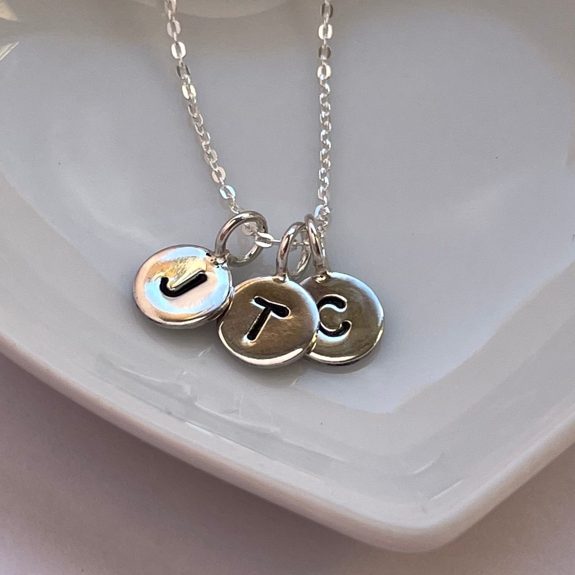 Handmade sterling silver initial necklace featuring an 8mm disc stamped with a single capital letter, displayed on an 18-inch silver trace chain.