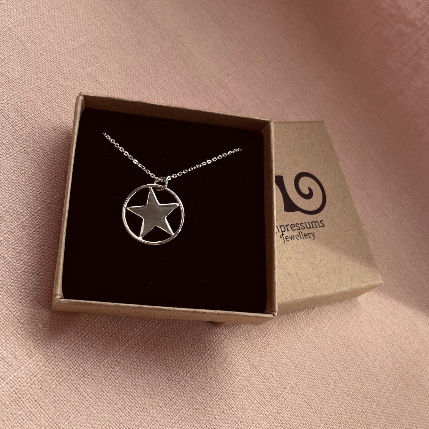A sterling silver star pendant necklace in an Impressums Jewellery branded gift box, ready for gifting.