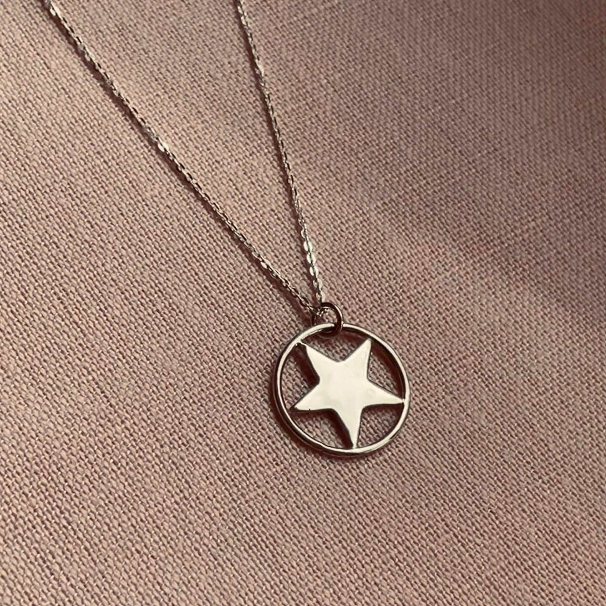 Handmade sterling silver star pendant necklace, featuring a five-pointed star set within a circular frame, displayed on an 18-inch silver trace chain.